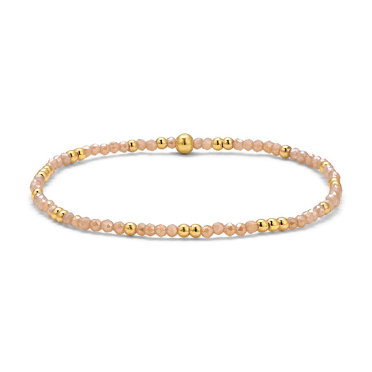 Beaded bracelet with gold and peach beads on a white background