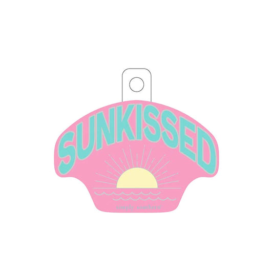 pink sticker with "sunkissed" scripted in blue and a sunrise graphic below. 