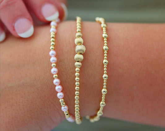 3 Piece Bracelet Set, All Gold, One with Pink and Gold Beads, One All Gold, and One 5 Larger Gold Beads