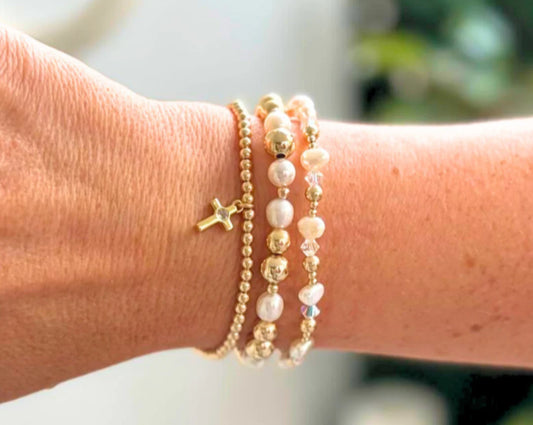 set of 3 beaded bracelets: one with a cross charm, the other two are gold bead, pearl and gemstones BEAD MATERIAL:&nbsp;GOLD FILLED, FRESHWATER PEARLS MATERIAL PENDANT: 18K GOLD PLATED STRETCHY LENGTH:&nbsp;6.5" OR 7" CLASP LENGTH:&nbsp;6" + 1.5" EXTENSION HIGH PERFORMANCE ELASTIC