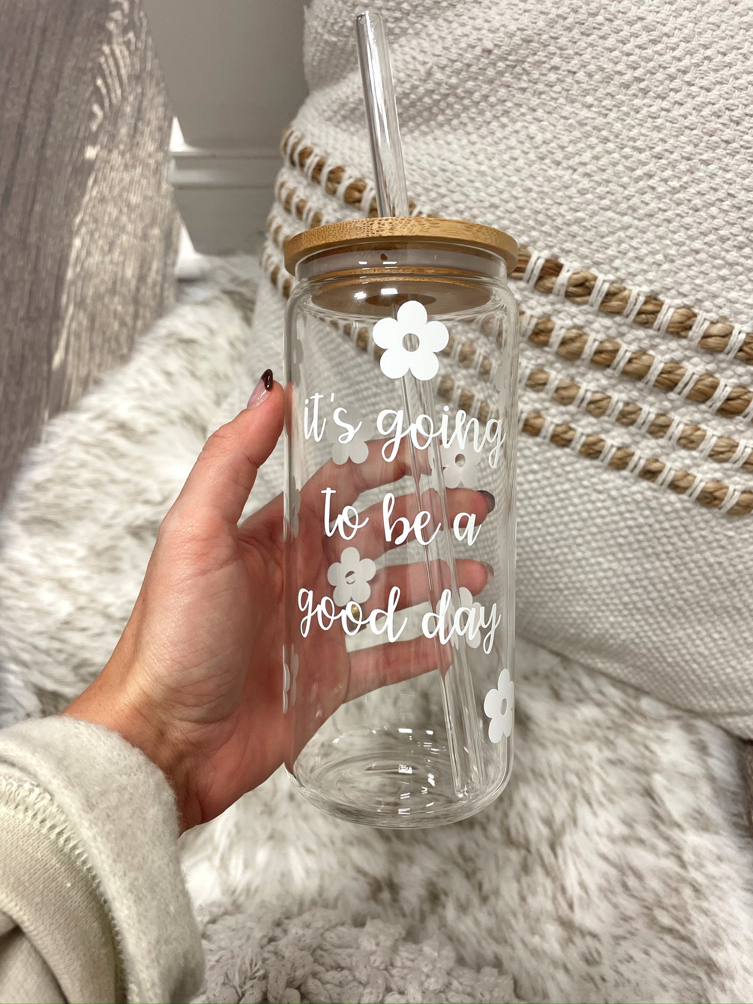 clear glass cup wtih straw that says its going to be a good day in white lettering with white flowers