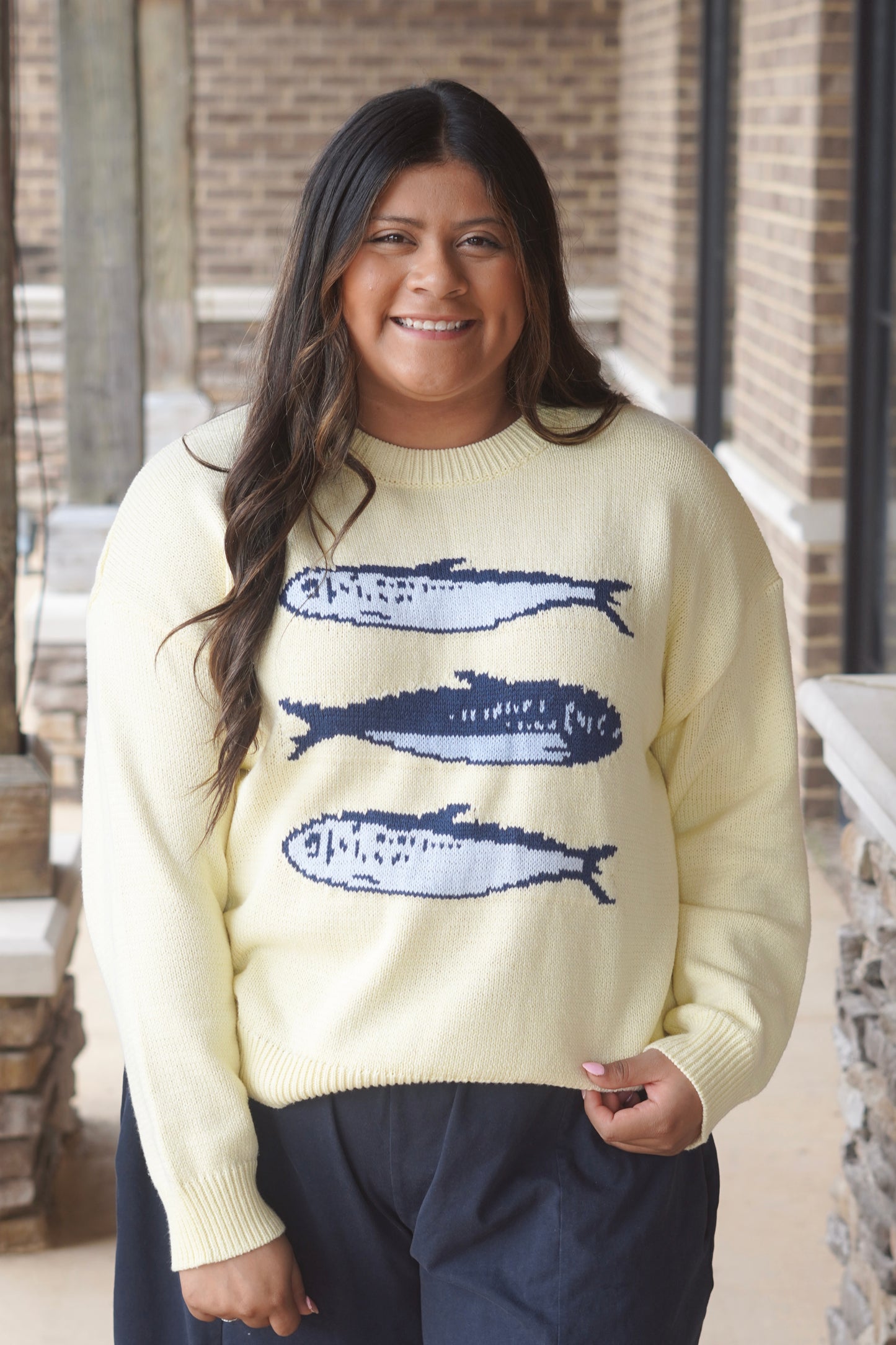 Women Wearing a Yellow Sweater with 3 Blue Fishes on it. 