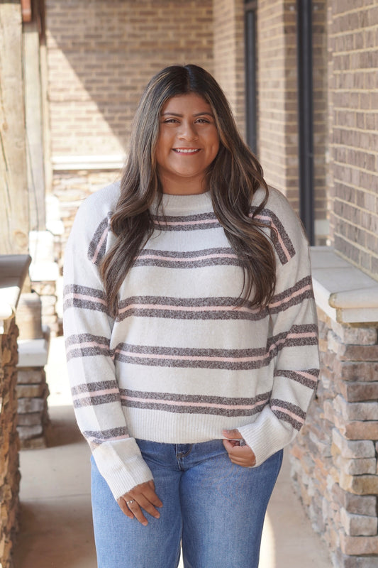 Women wearing a pink and grey Striped ivory Knit Sweater, Round Neckline, Long Sleeves, Relaxed Fit, Full Length. 