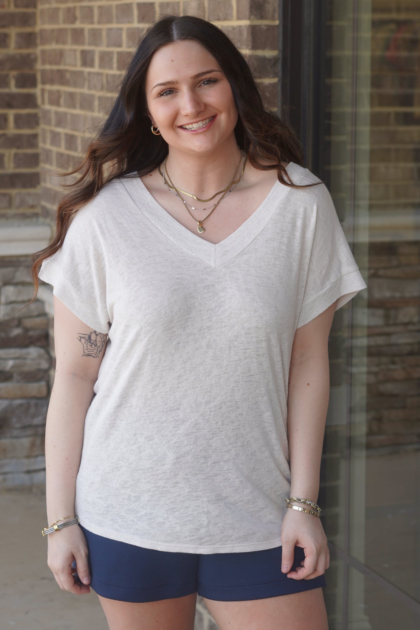 Women wearing a cream short sleeve  v-neck top paired with navy shorts. 