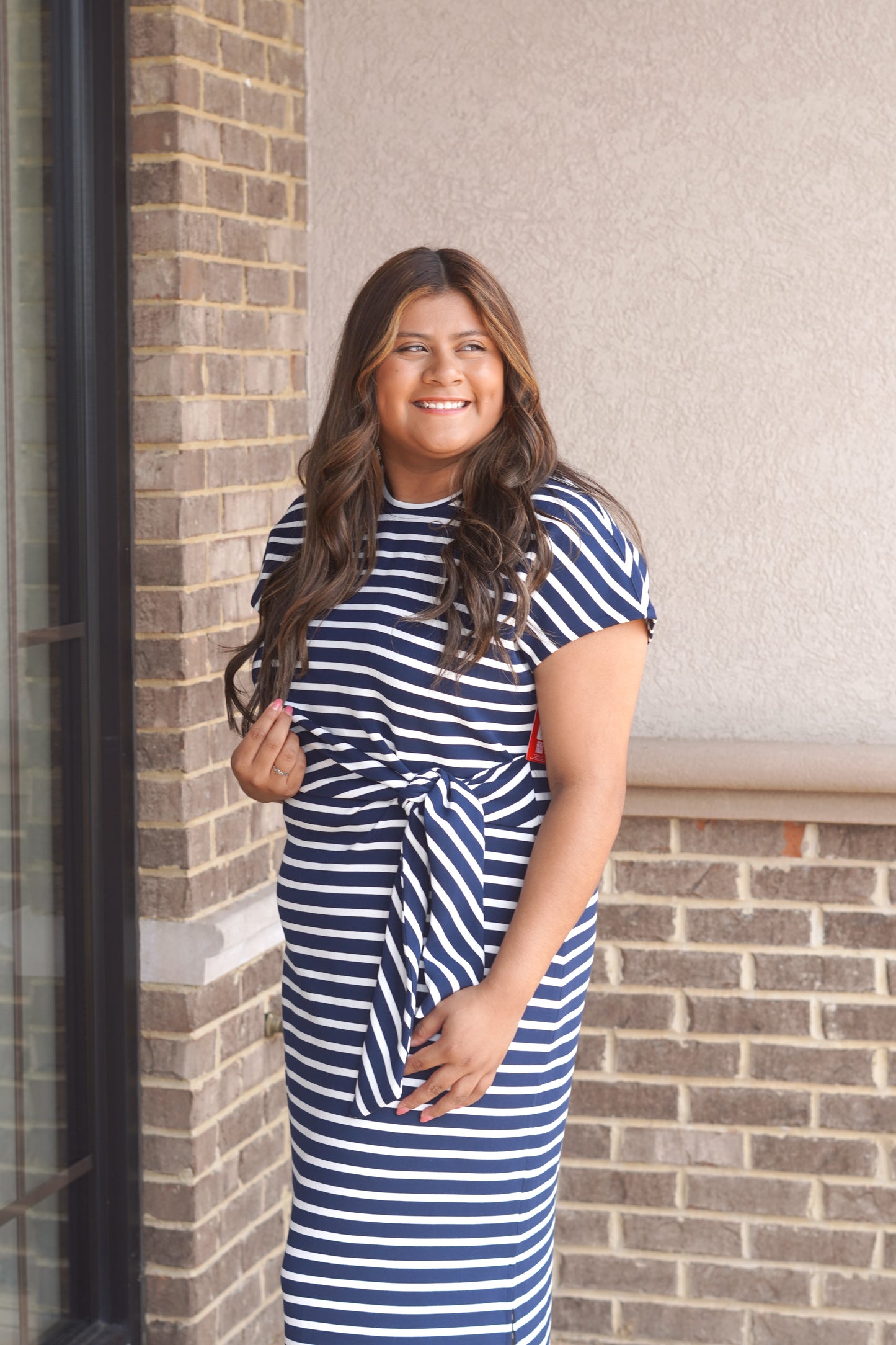 Women Wearing a Navy and White Striped Maxi Dress, Round Neckline, Tie-Waist Detail, Short Sleeve. 