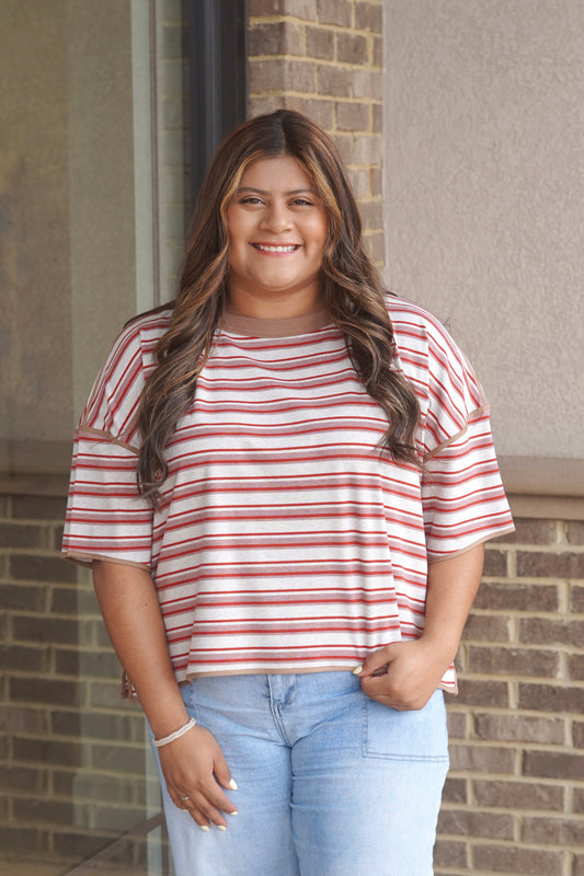 Women wearing short sleeve red and white striped top, with a brown trim. 