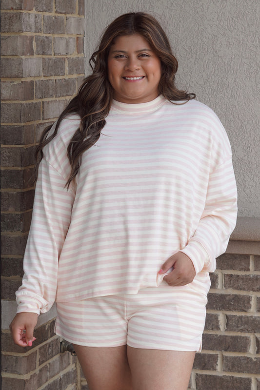 Woman wearing a Pink and White striped long sleeve top with crew neckline.