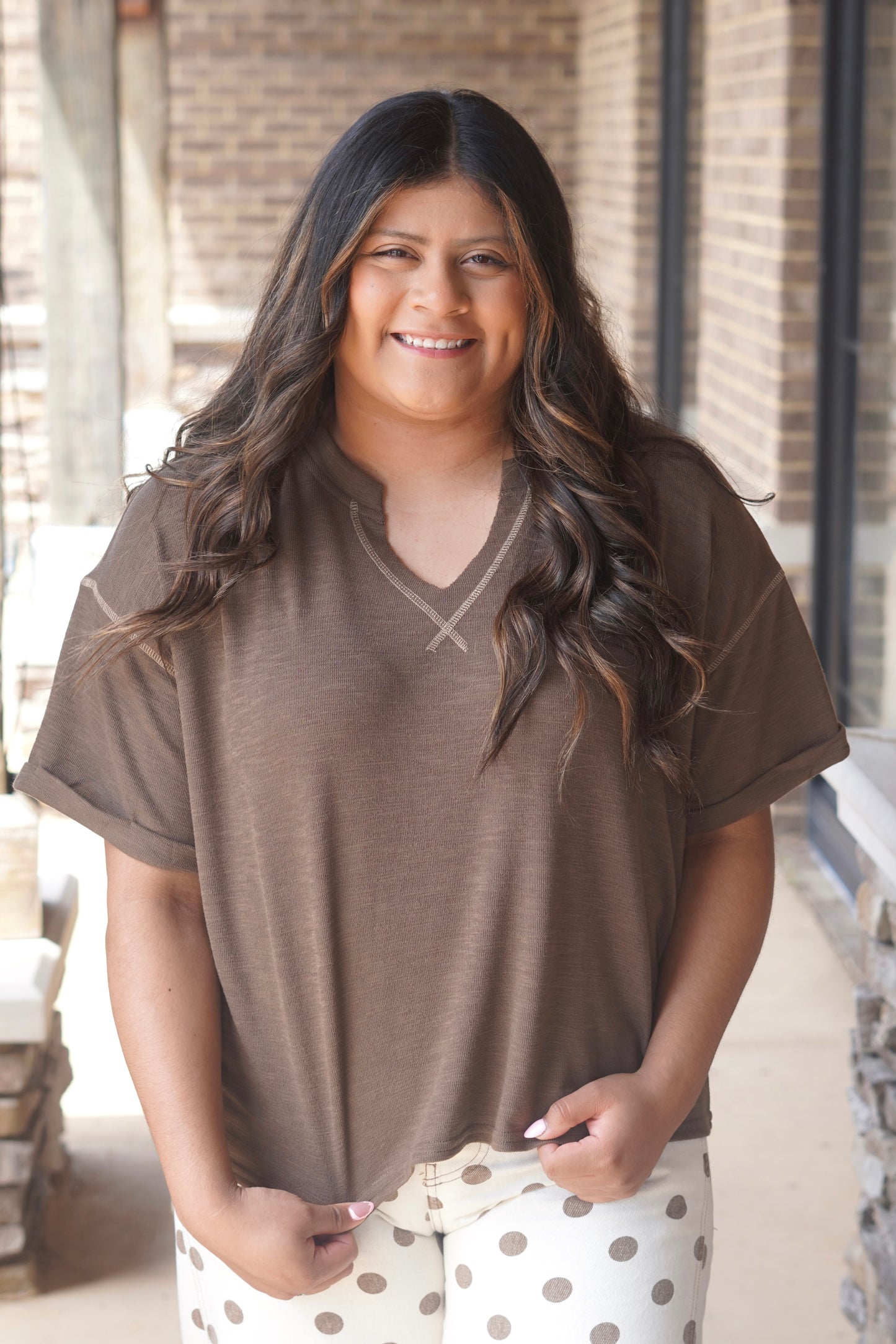 Women Wearing a Brown Top, Short Sleeve, V-Neckline, with Contrast Stitching. 