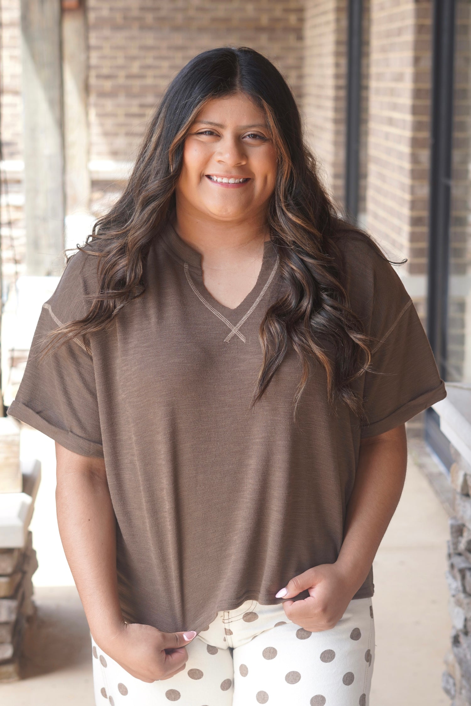 Women Wearing a Brown Top, Short Sleeve, V-Neckline, with Contrast Stitching. 