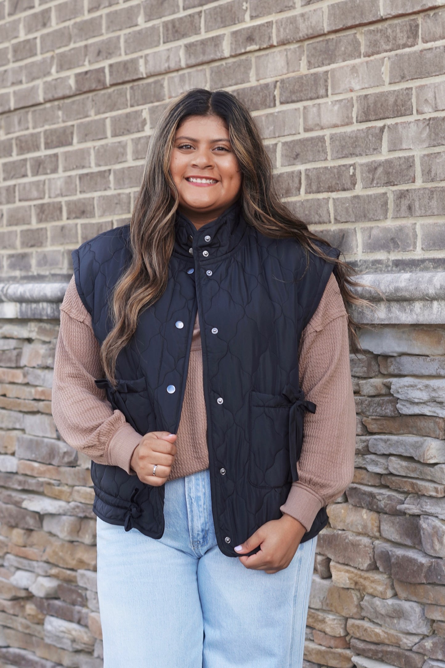 Women wearing a Burgundy Bow Detail Quilted Puffer Vest, Collar Neckline, Snap Button Down, Full Length, Pockets, style with a  mocha top and jeans. 