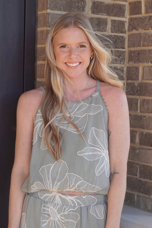 women wearing a sage top with ivory floral embroidery print, sleeveless, round neckline.