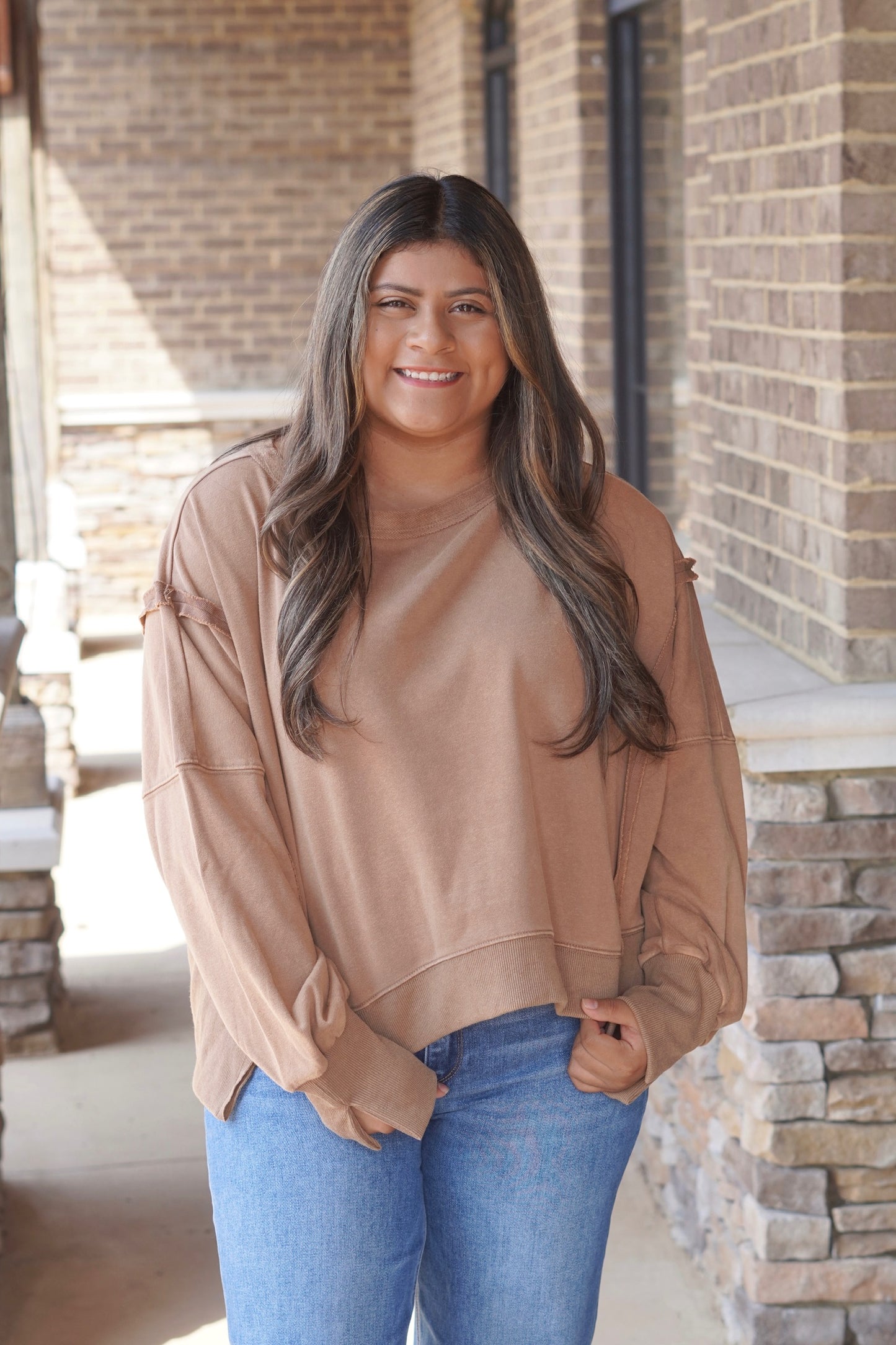 Women wearing Cropped Sweatshirt in a mocha color, Round Neckline, Long Sleeves.