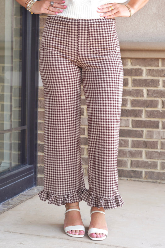  brown and white gingham pants that flare out slightly and have ruffled hems.