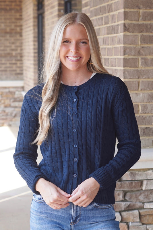 Women wearing a Navy Cable Knit Cardigan, Round Neckline, Button Up, Long Sleeves, Waistline Length. 