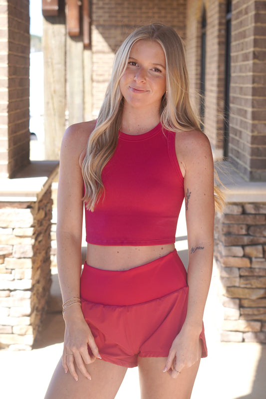 Women Wearing a pink mid-length tank, crewneck line, paired with pink shorts 