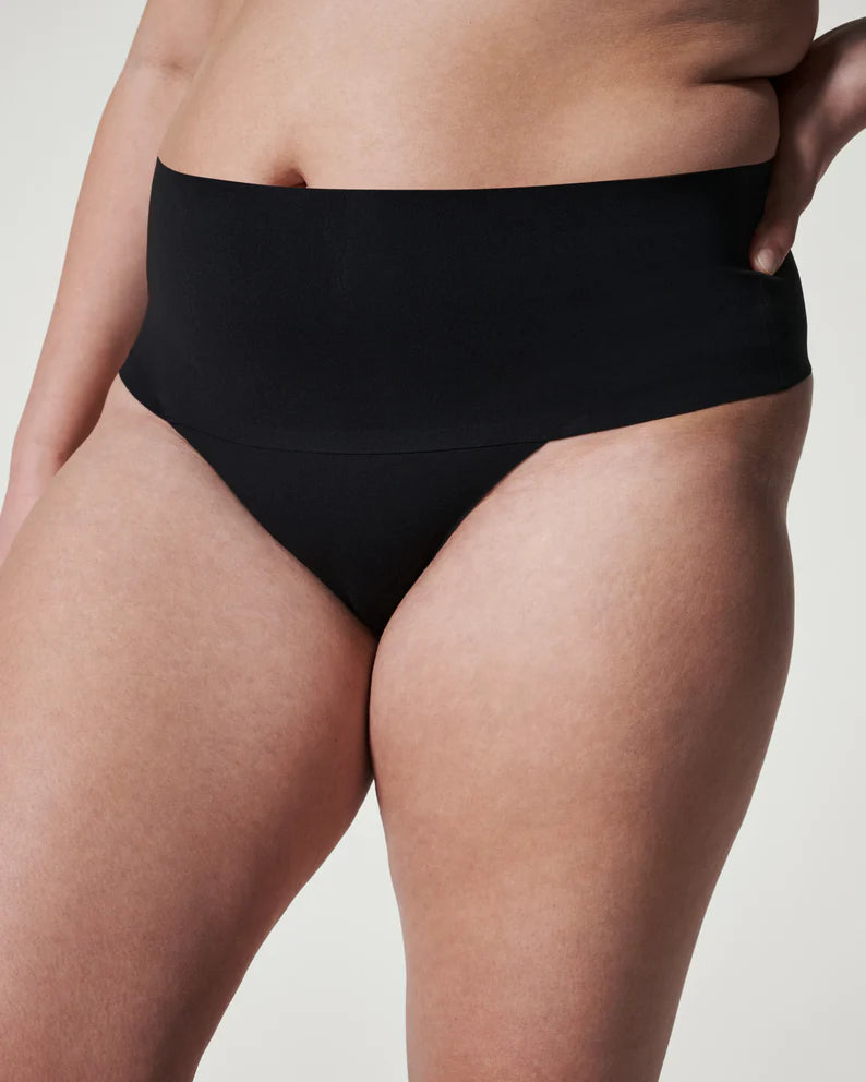 Spanx Undie-Tectable Thong Black Rise: 26" Full coverage front, thong back  77% Nylon, 23% Elastane. Gusset: 100% Cotton. Care:Machine Wash Cold, Gentle Cycle. Only Non-Chlorine Bleach When Needed. Lay Flat To Dry. Do Not Iron.