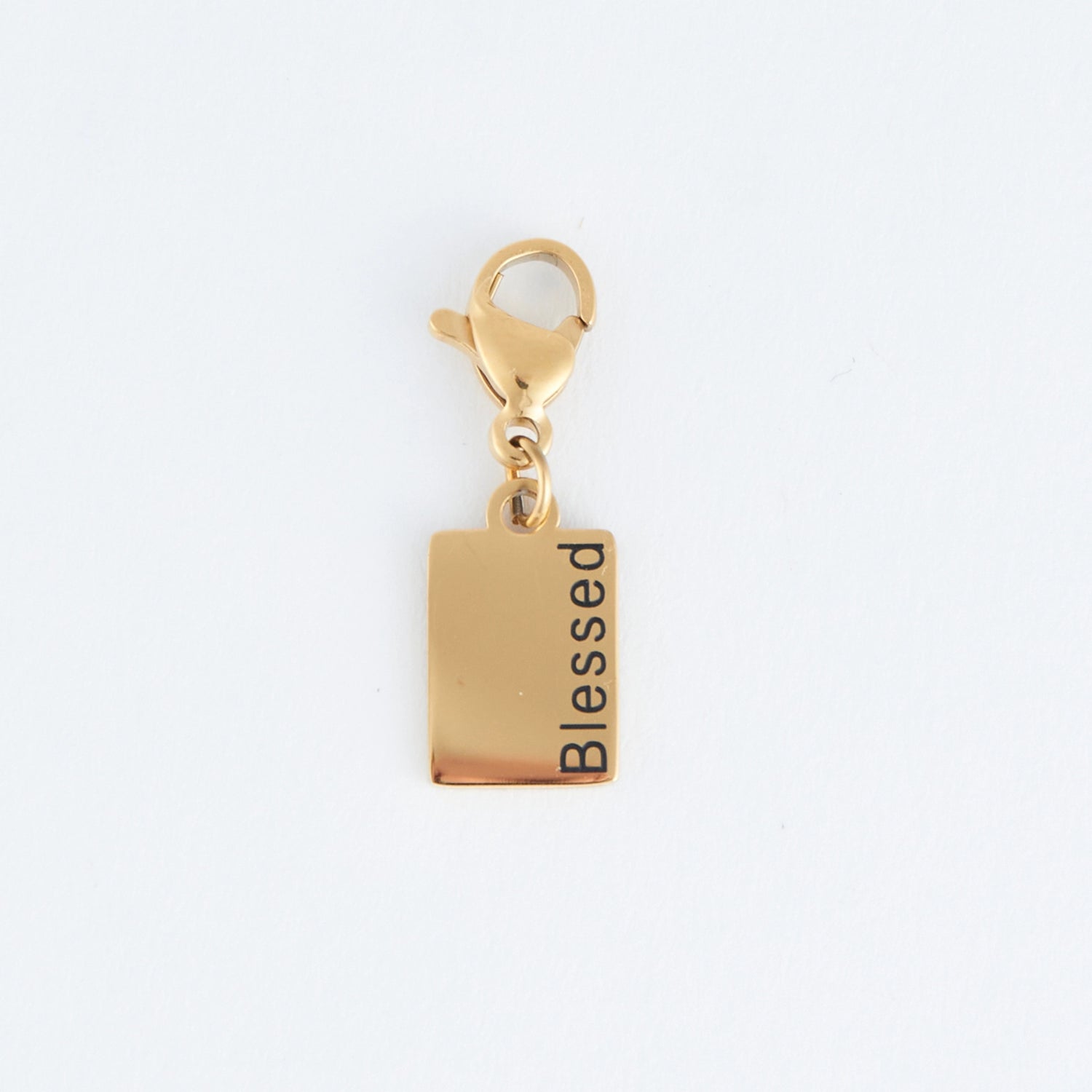 Gold rectangle charm with the word Blessed written, with a lobster clap. 