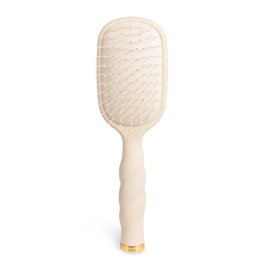 Oval hair brush, beige handle, gentle glide bristle, textured handle with gold trim. 