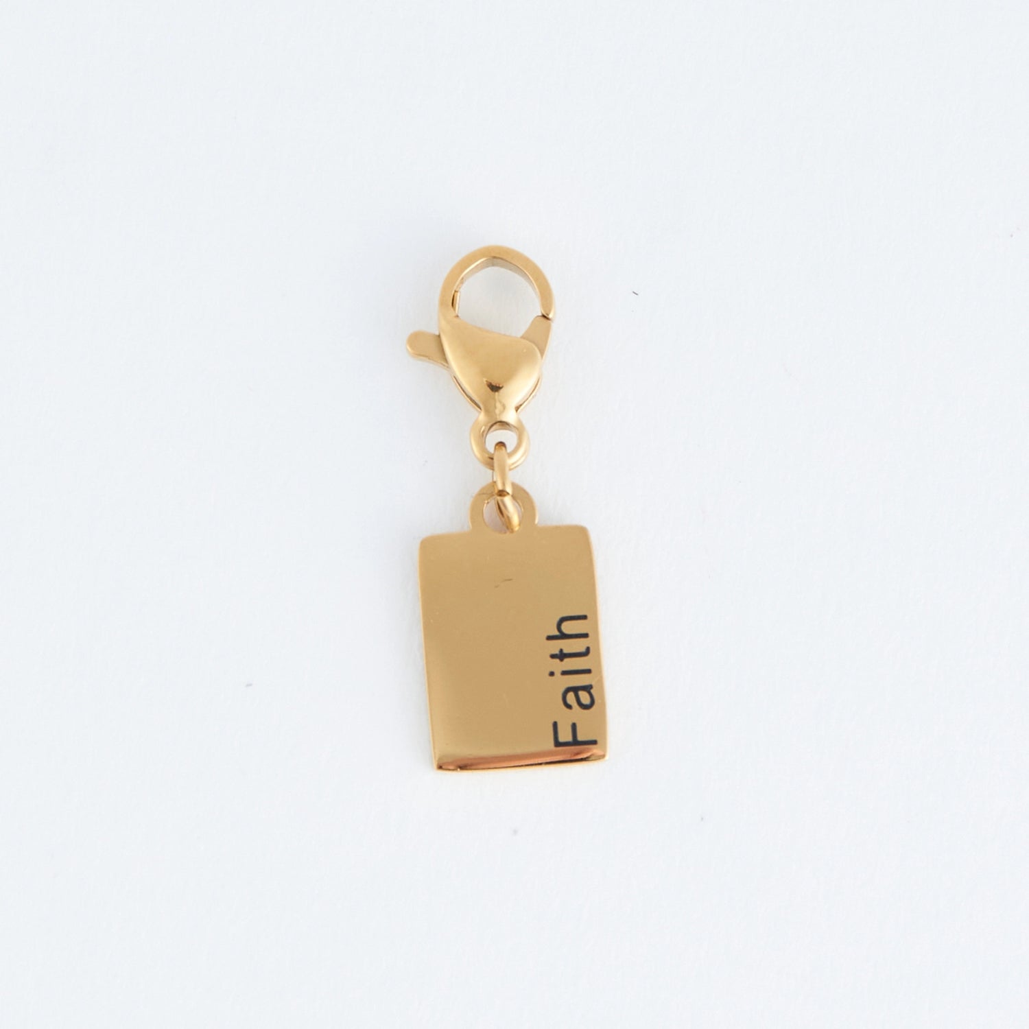 Gold rectangle charm with the word faith written, with a lobster clap. 