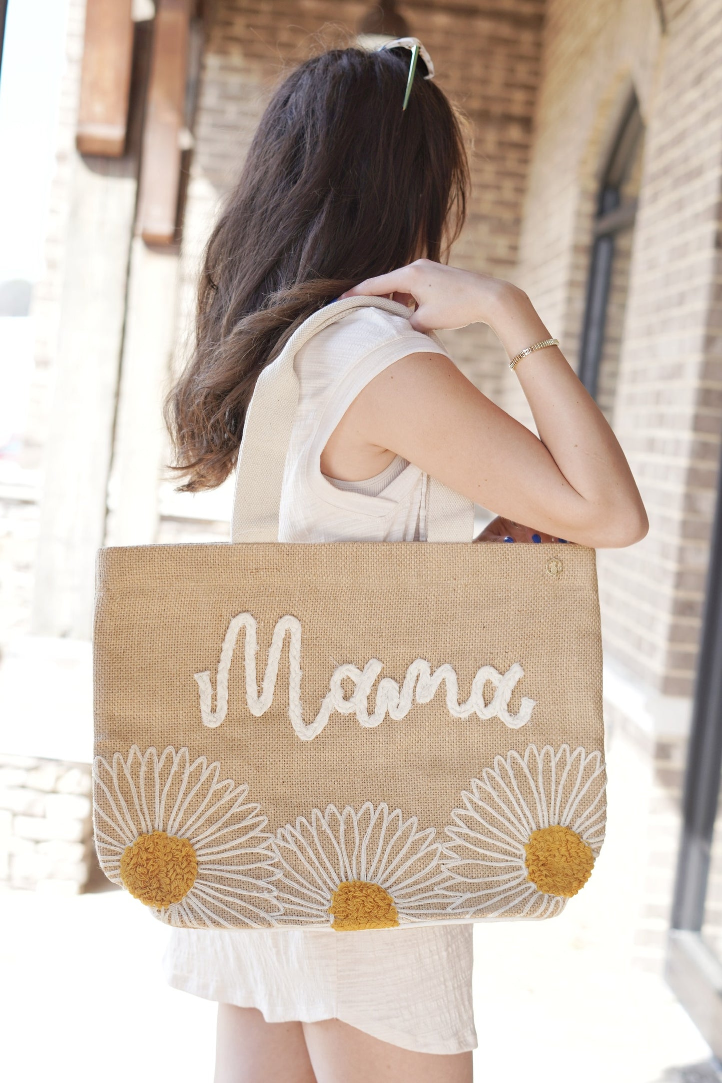 sand colored large tote bag with stitched daisies and "mama" spelled in stitched lettering