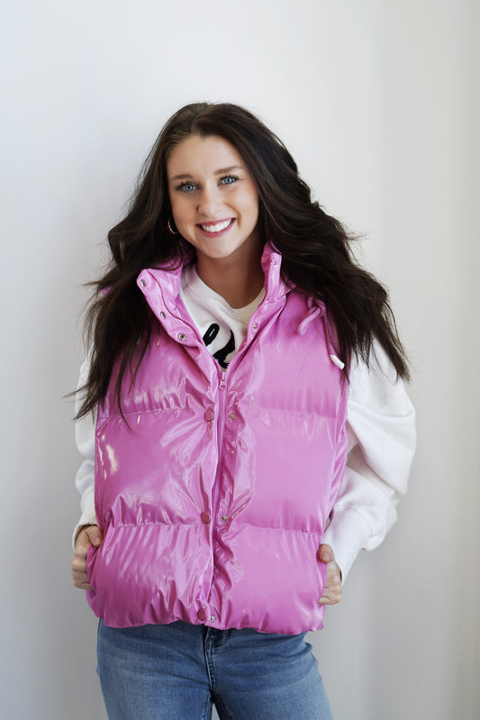 Shimmer Faux Leather Vest Hooded Neckline Full Length Sleeveless Button And Zipper Closure Down Vest Fitted Colors: Pink Faux Leather Material Model Is Wearing Size: Small 55% Polyester