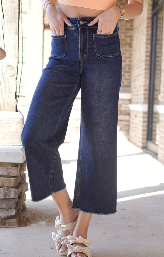 <ul> <li>Faye Front Pocket Dark Wash Jeans</li> <li>Super High Rise</li> <li>Zipper Fly Closure</li> <li>Retro Front Pockets</li> <li>Dark Blue Denim Wash</li> <li>Cropped Wide Leg Fit</li> <li>92.5% Cotton, 5.5% Polyester</li> </ul>
