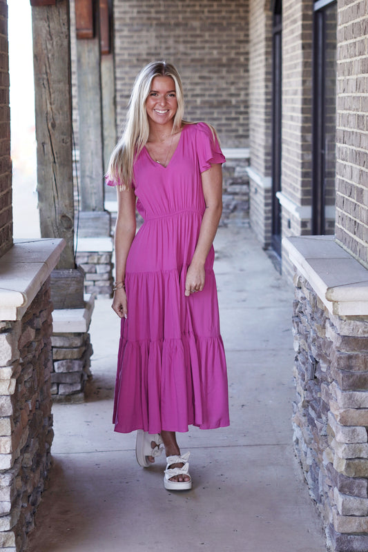 France Flutter Sleeve Tiered Ruffle Midi Dress V-Neckline Short Flutter Sleeves Subtle Tiered Ruffle Detail Color: Magenta Relaxed Fit Midi Length Pockets 100% Rayon