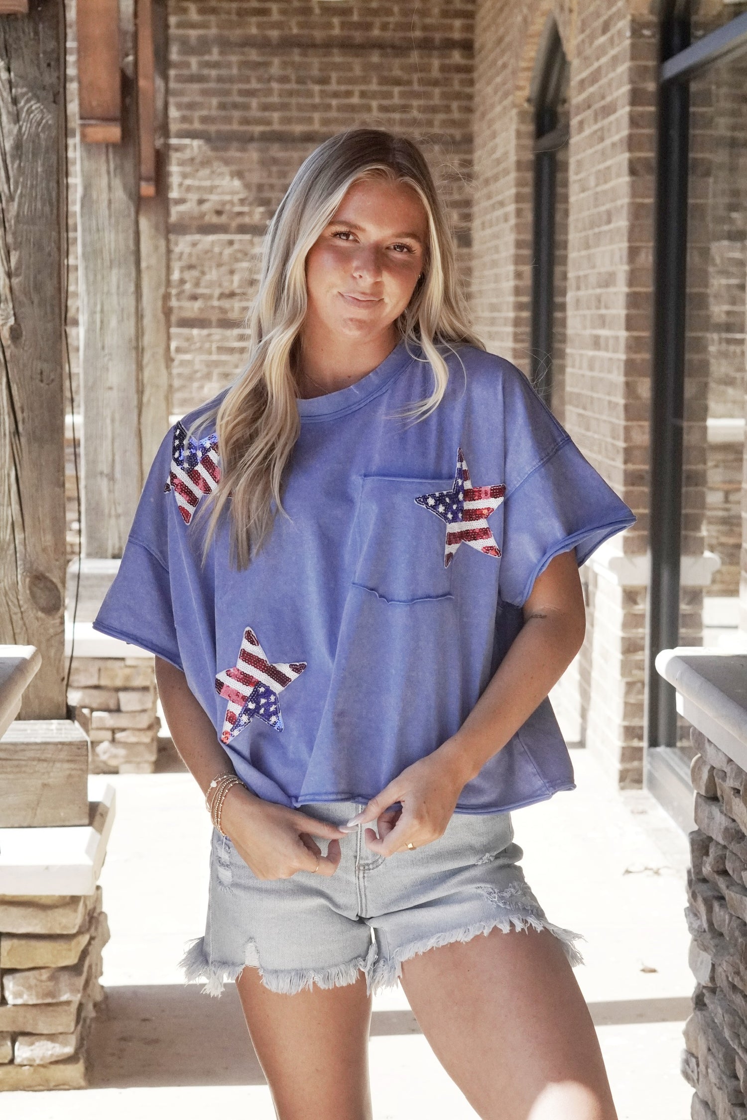 American Made Star Sequin Patch Top Round Neckline Sequin Star Patches Short Sleeves Color: Washed Blue Pocket Tee Cropped Relaxed Fit Fabric Content: 65% Cotton, 35% Polyester