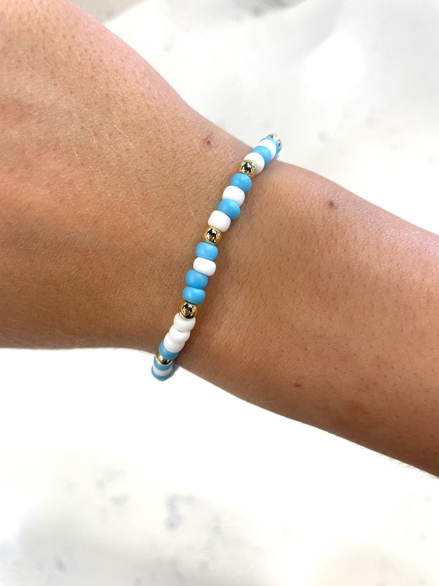 bright blue, white, and gold beaded bracelet