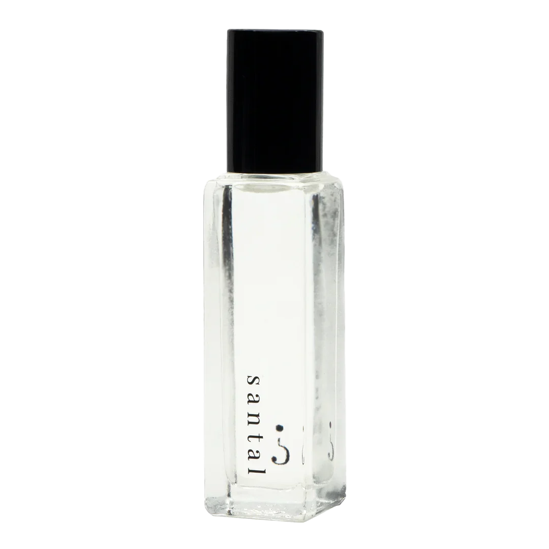 A clear small bottle with a black lid and "Santal " written in black. 