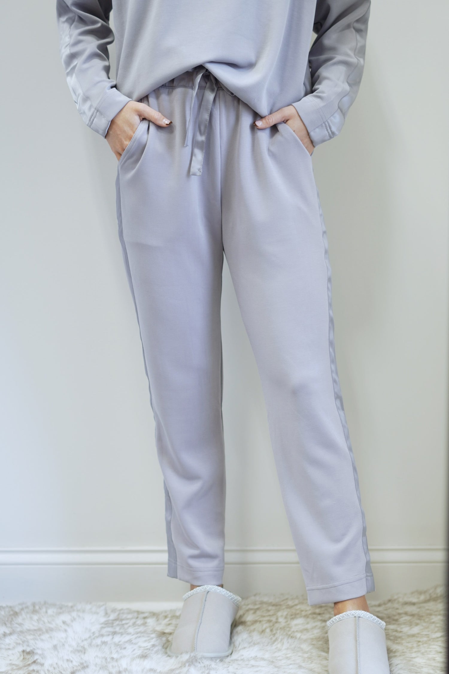 So Sleek Satin Trim Athletic Pant Mid Waisted Elastic Waistband with Tie Satin Trim Detail on Side of Legs Colors:  Mystic Grey Tapered Pant  Ankle Length Relaxed Fit 48% Modal, 46% Polyester, 6% Spandex