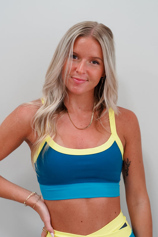 Continuing the color block trend, we’re bringing back the Spot On Color Block Bra this season. This bra is made using our sweat-wicking and supportive Pure Performance fabric and features a scoop neckline with removable pads. The straps lead to a low cut back for a sporty look. Pair with the Color Block Bike Short.  Fabric Content: 80% Polyester 20% Spandex