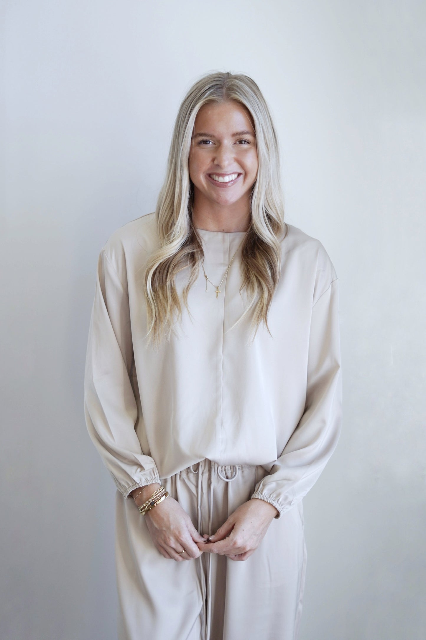 See Me in Satin Waist Tie Top Round Neckline Long Cinched Sleeves Vertical Hem Detail on Front of Top Hem Tie for Waist Colors: Cream Relaxed Fit Full Length 100% Polyester