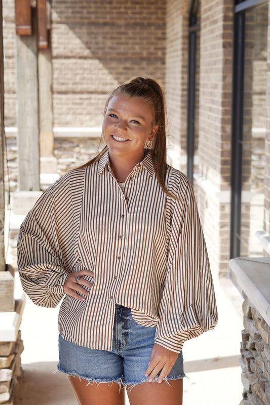 Voluminous Sleeved Stripe Button Down Top Collared Neckline Long Voluminous Cuffed Sleeve Brown and Cream Striped Button Down Feature Split Hem Full Length&nbsp; Relaxed Fit 50% Cotton, 50% Polyester