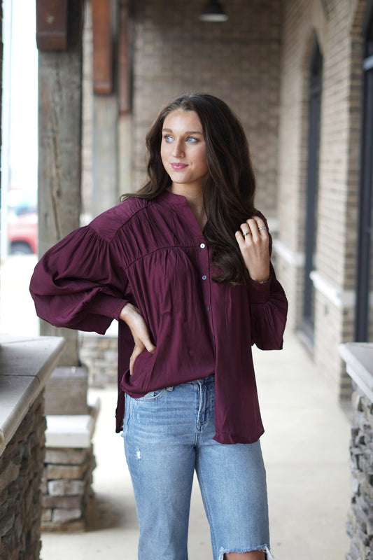 Bella Burgundy Button Up Blouse Button Up Subtle V-Neckline Long Smocked Cuff Sleeves Color: Burgundy Full Length Relaxed Fit Polyester: 60% Rayon, 40% Polyester
