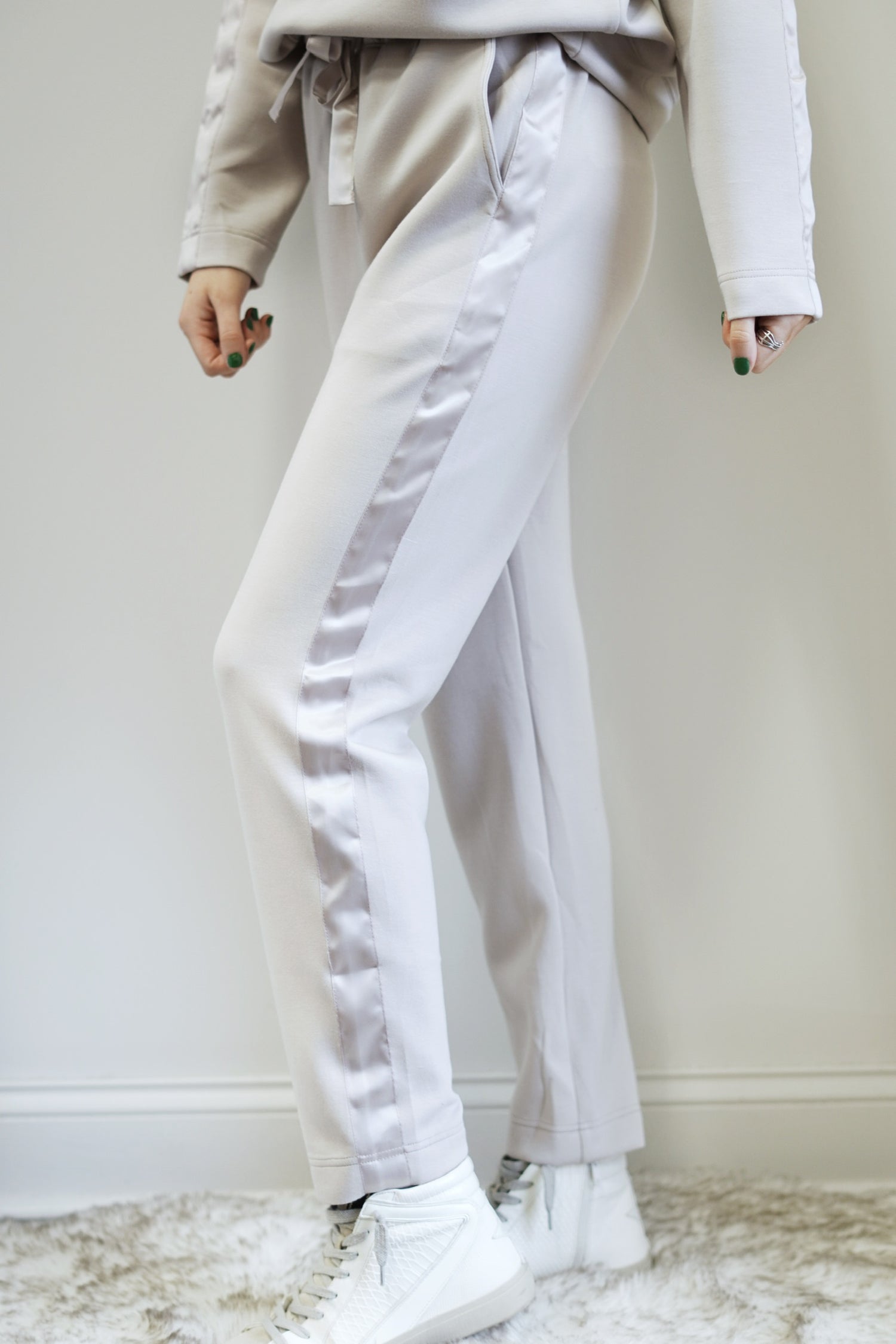 So Sleek Satin Trim Athletic Pant Mid Waisted Elastic Waistband with Tie Satin Trim Detail on Side of Legs Colors:  Cream, Tapered Pant  Ankle Length Relaxed Fit 48% Modal, 46% Polyester, 6% Spandex