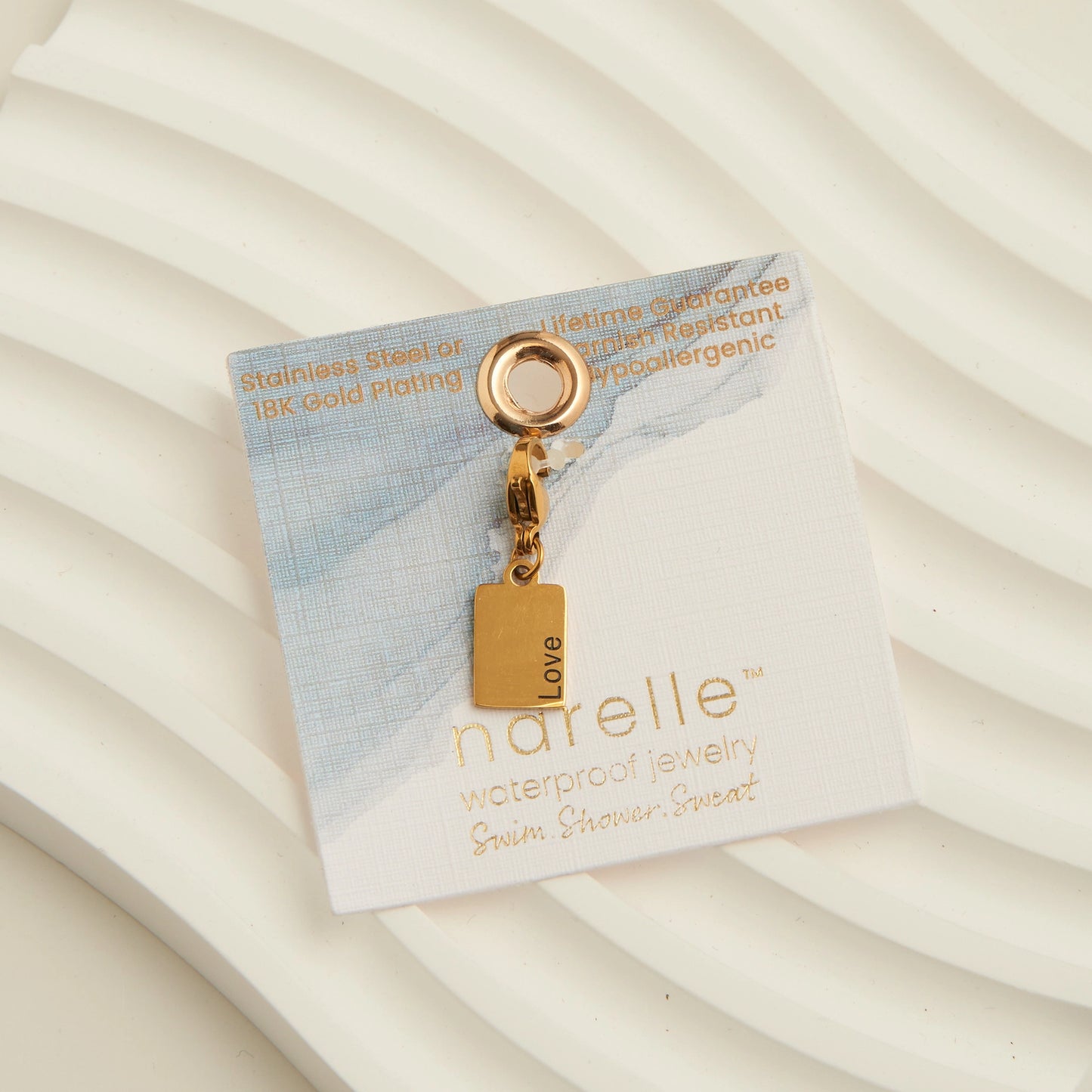 Gold rectangle charm with the word Love written, with a lobster clap. 