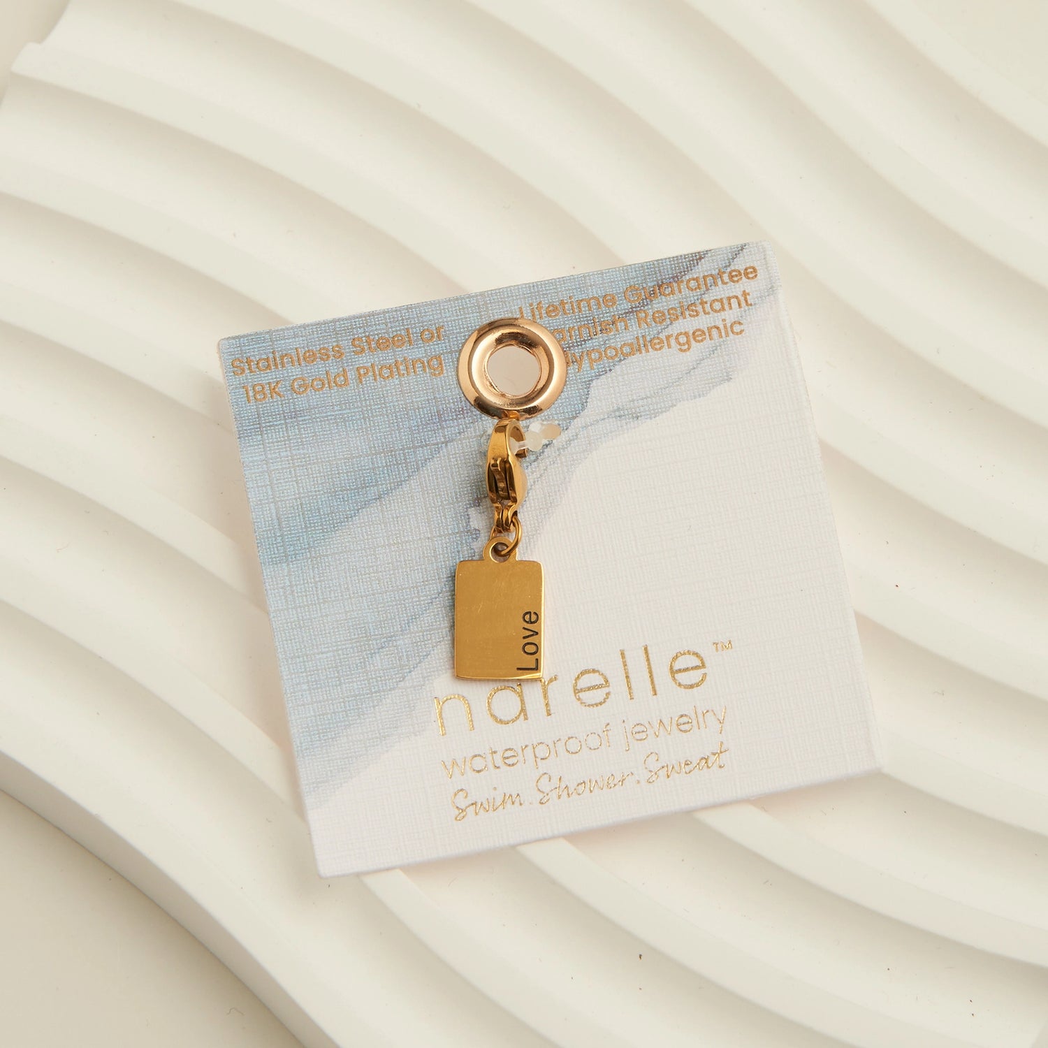 Gold rectangle charm with the word Love written, with a lobster clap. 