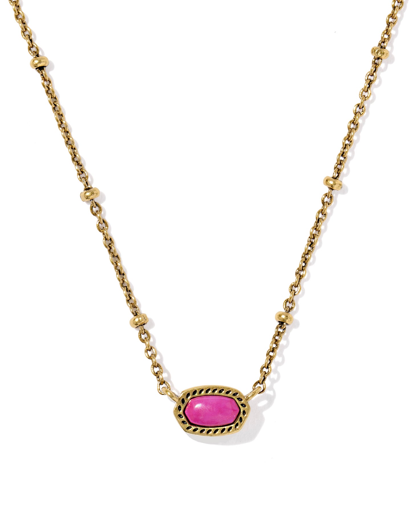 Gold necklace with a oval pink stone pendant, the chain has a small circular details and the pendant is set within a textured gold frame. 