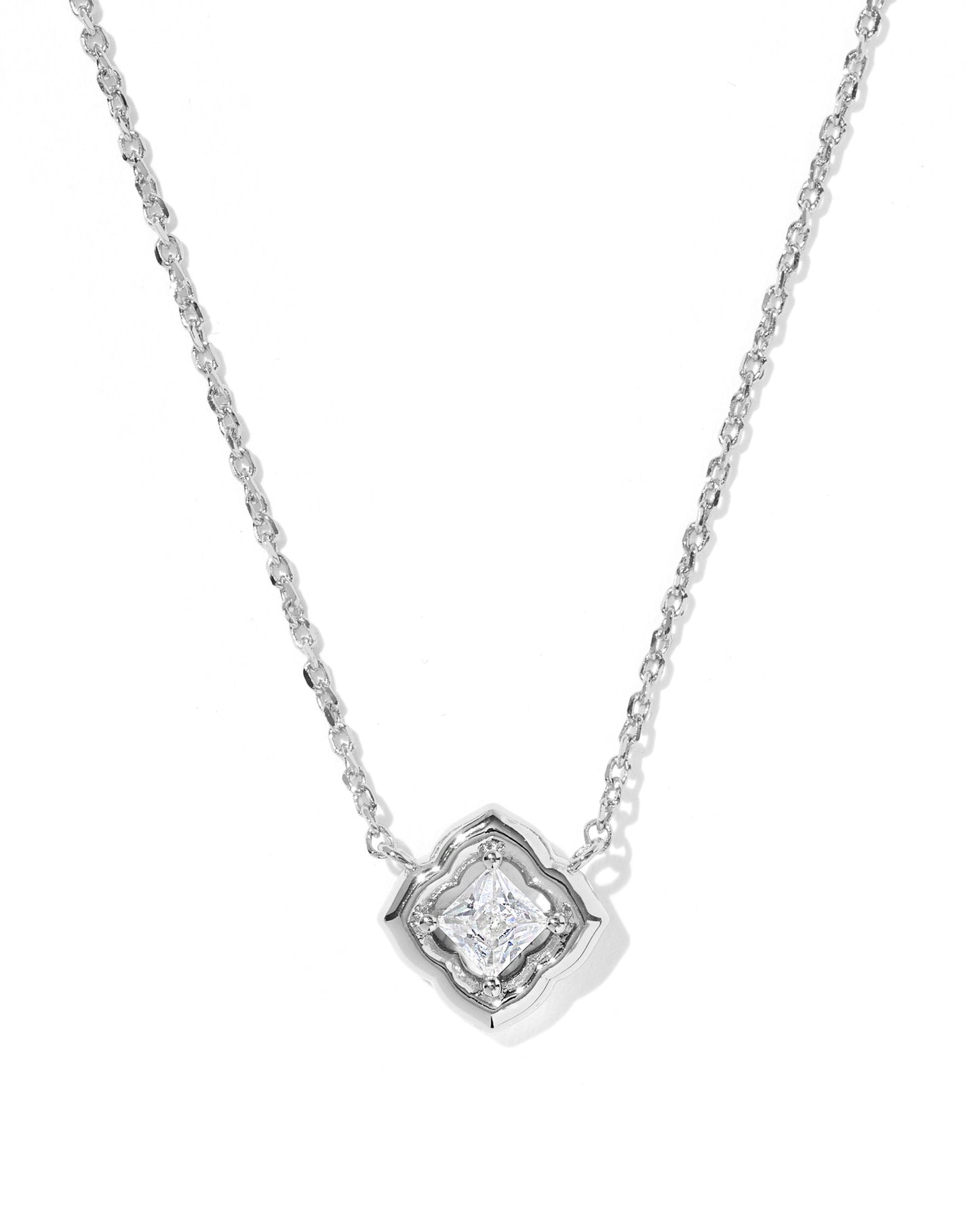 A silver-tone chain necklace with a geometric diamond-shaped pendant featuring a clear central gemstone, shown on a plain white background.