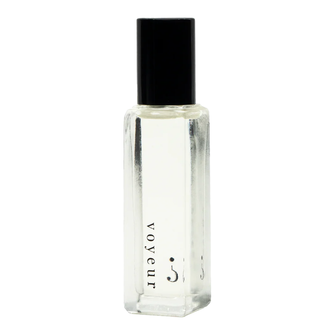 A clear small bottle with a black lid and "voyeur " written in black. 