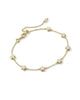 Gold chain bracelet with white flower evenly space out. 