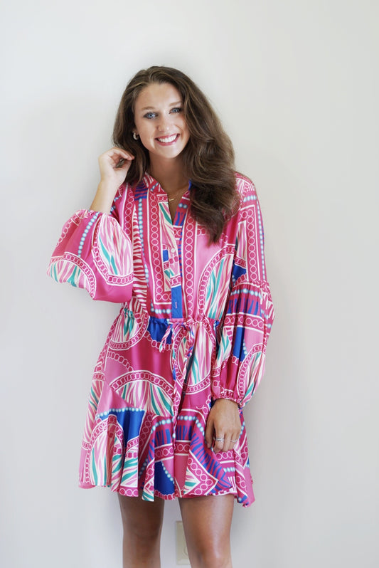 Lauren Adjustable Balloon Sleeve Dress Split Neckline Long Sleeved with Elastic Cuffs Drawstring Waist Band Front Button Closure  Lined Skirt and Unlined Top and Sleeves  Fuchsia Print Billowy Fit Mini Skirt 97% Polyester  3% Spandex Hand Wash Cold, Do Not Bleach, Lay Flat To Dry, Cool Iron If Needed Model Is Wearing a Size Small