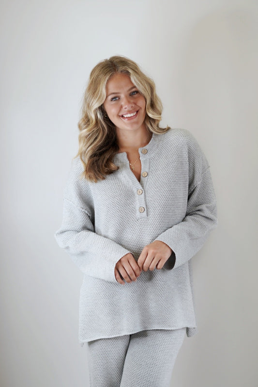 Honey Oversized Henley Sweater Top Henley Neckline w/ Functional Buttons Long Sleeve High Low Hem w/ Side Slits Heather Grey Color Relaxed Fit 55% Acrylic, 45% Cotton