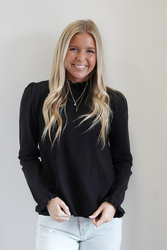 Rae Ruffle Neckline Sweater High Neckline w/ Ruffle Detail Long Sleeves w/ Ruffle Hem Ribbed Hemline Colors: Black Relaxed Fit Full Length 100% Acrylic