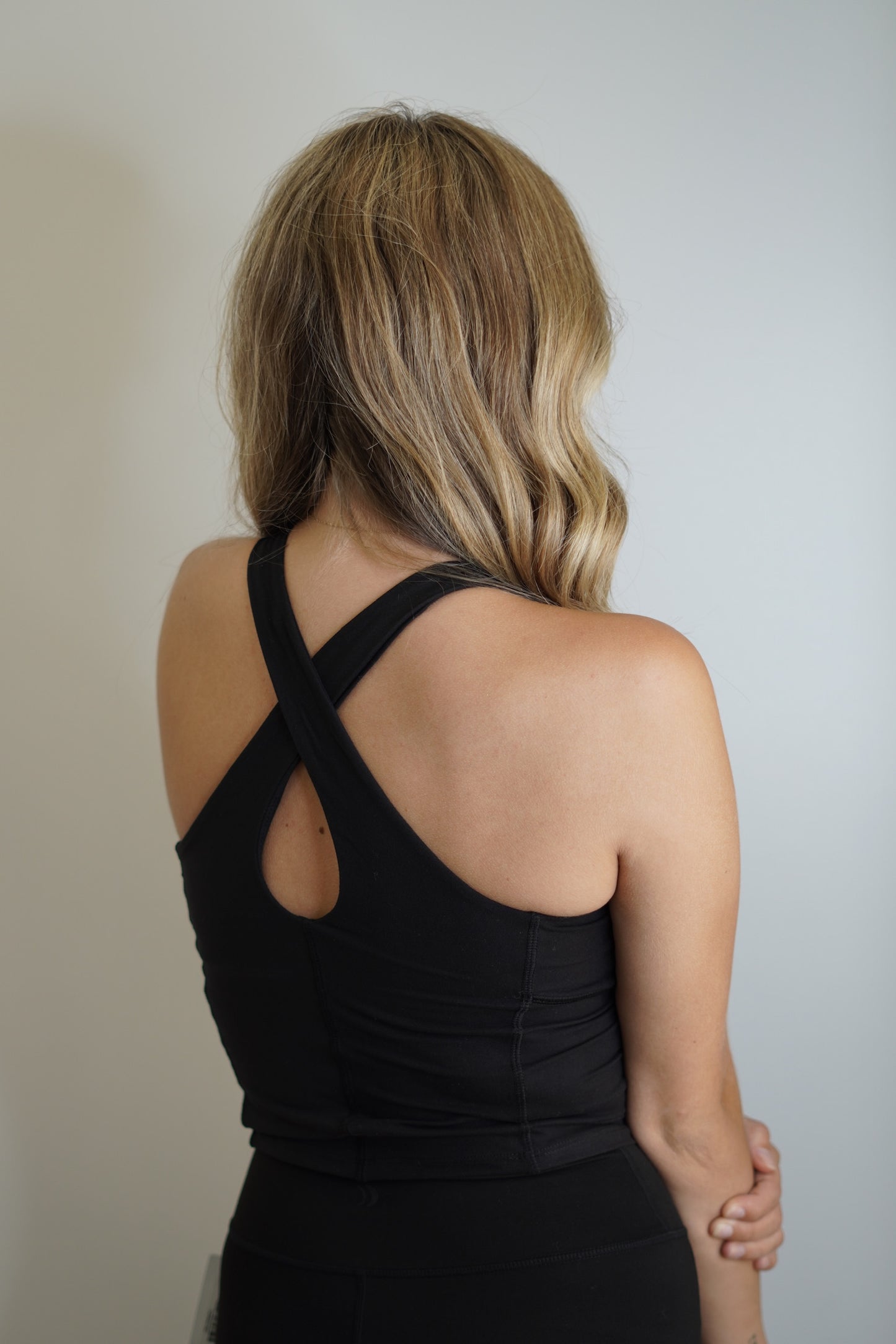 Ciara Criss-Cross Back Athletic Top High Neck Sleeveless Butter Yoga Fabric, Back Key Hall Detail, Bra Pads Included Black Cropped Length, Fitted Top 84% Polyester, 16% Spandex Hand Wash Cold with Like Colors, Do Not Bleach, Tumble Dry Low, Do Not Iron, Do Not Dry Clean Model is wearing size small