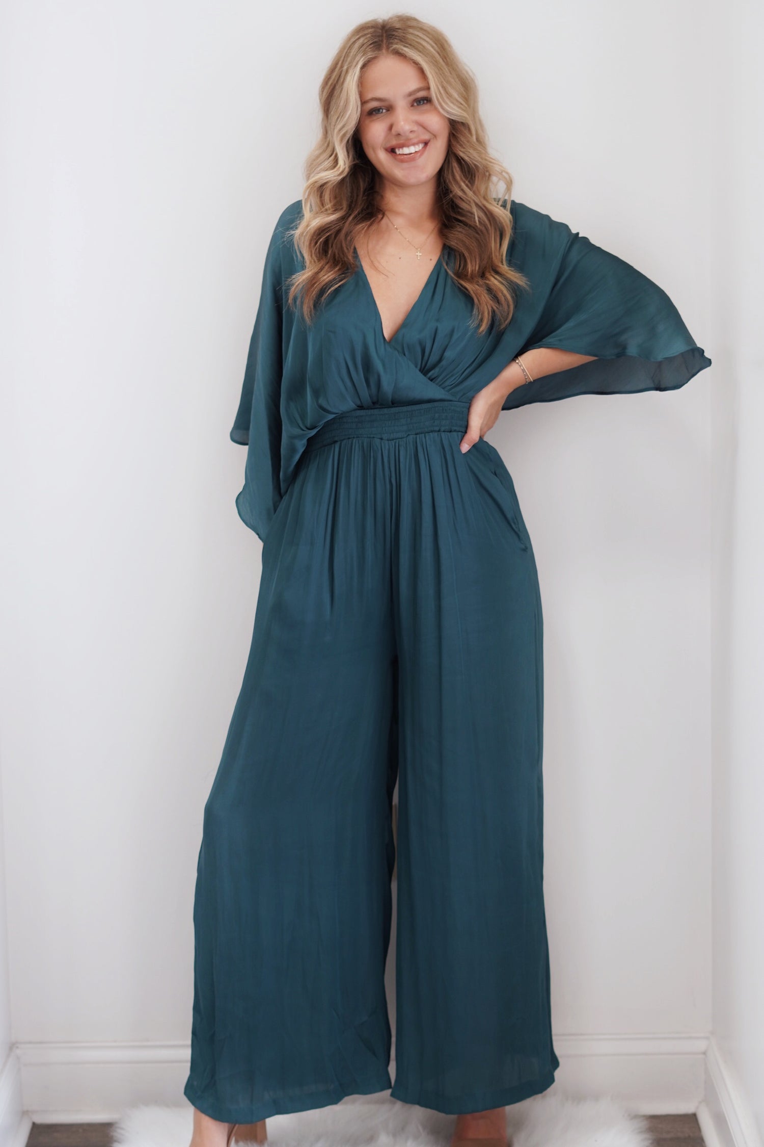 Lilah Wide-leg Jumpsuit V-Neck with Smocked Waist Back Keyhole with Button Closure Caped Sleeve Color: Green Full Length 100% Polyester Dry Clean Only Model is wearing a size small