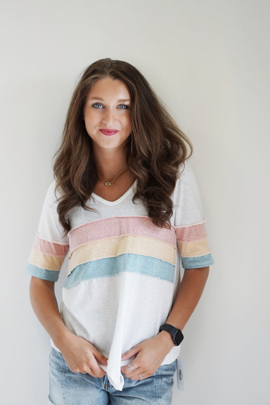 Lauren Color Block Triblend Top V-Neck  Short Sleeved  Color strips in the middle so shirt and on sleeve  White, Pink, Orange, and Blue  48% Polyester  37% Cotton 11% Rayon 4% Spandex Hand Wash Cold, Do Not Bleach, Hang or Line Dry  Model is wearing a size: small 