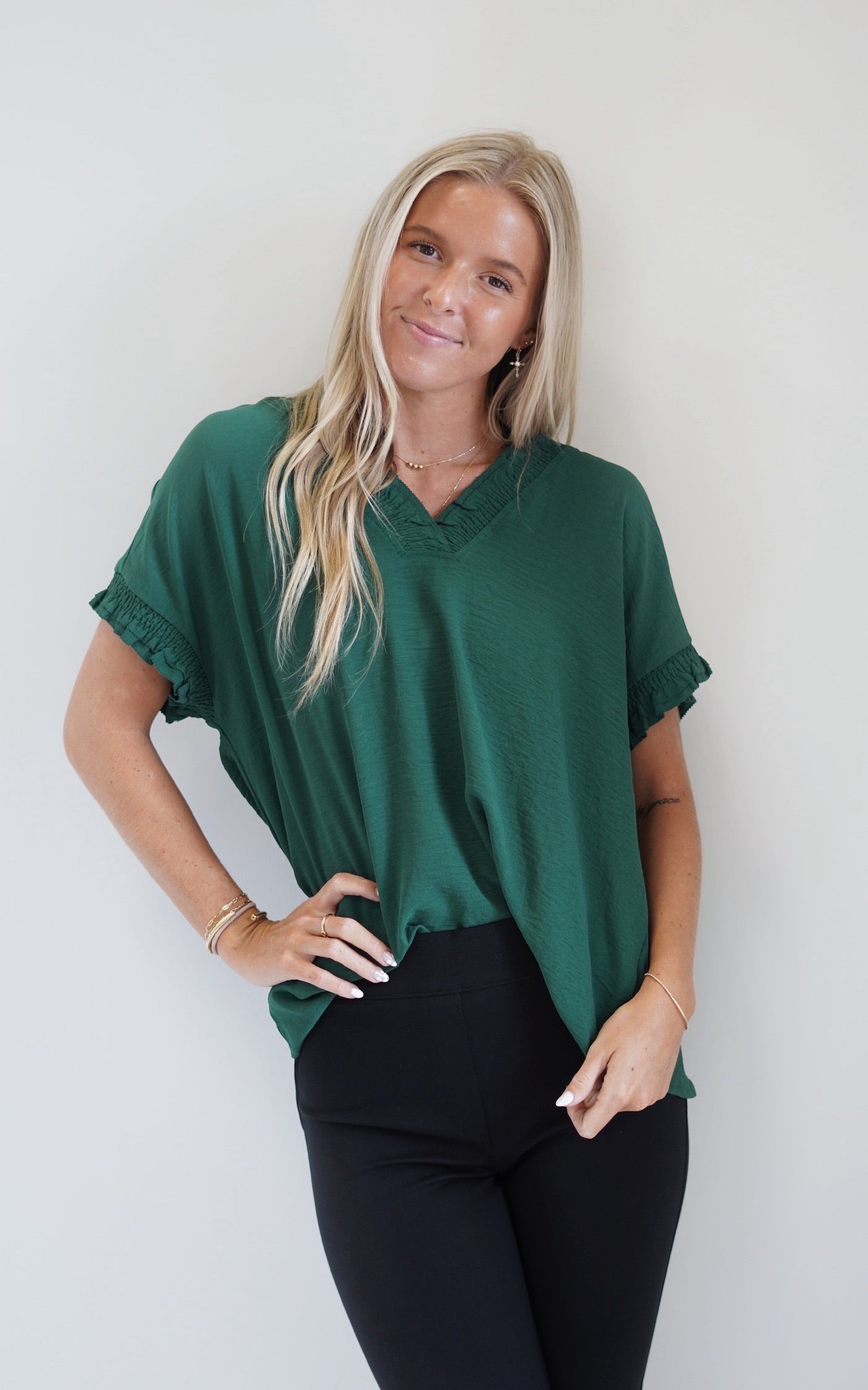 Sully Smocked Neckline Blouse Smocked V-Neckline Short Sleeve Smocked and raw hem detail on the neckline and sleeve cuffs  Forest Green Color Full Length Loose Fit 100% Polyester