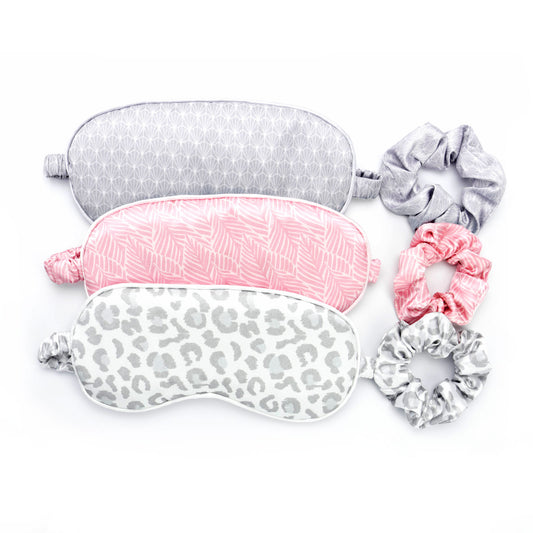 Multi-colored and printed eye masks and scrunchies set. Grey geometric, pink leaf, and grey cheetah print set options.